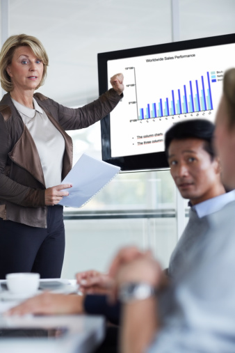 Confident businesswoman giving presentation in conference meeting