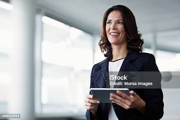 Happy Businesswoman Holding Digital Tablet Stock Photo - Download Image Now - Women, Businesswoman, Expertise