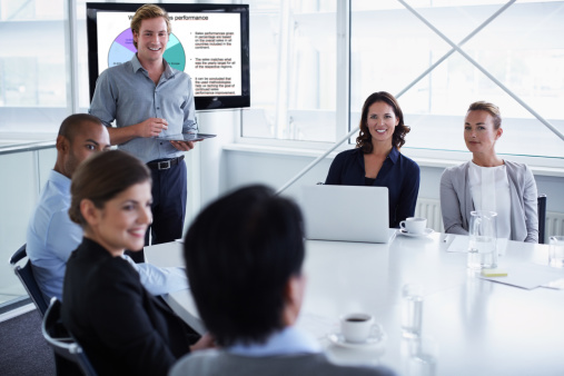 Businessman discussing with colleagues during presentation in conference meeting