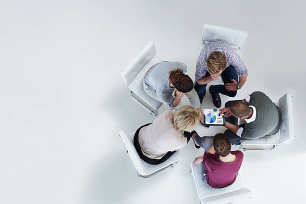 Businesspeople using digital tablet together High angle view of businesspeople using digital tablet together in office directly above stock pictures, royalty-free photos & images