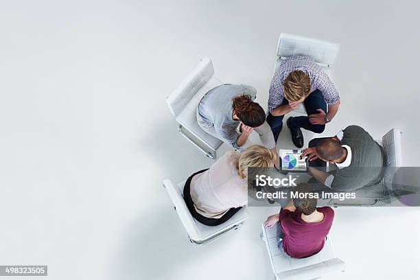 Businesspeople Using Digital Tablet Together Stock Photo - Download Image Now - Teamwork, Business, Meeting