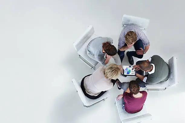 High angle view of businesspeople using digital tablet together in office