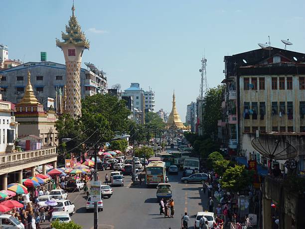 Clock Tower in Mahabandoola street, Yangon Clock Tower and Mahabandoola street in Downtown Yangon. On the street there is a busy street market. yangon photos stock pictures, royalty-free photos & images
