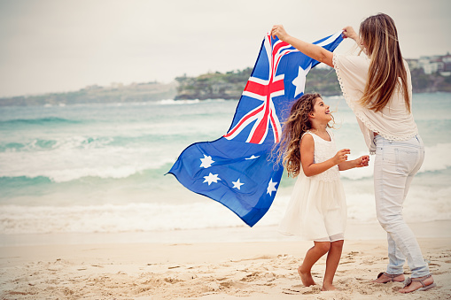 Mother and daughter with Australian flag at the beach