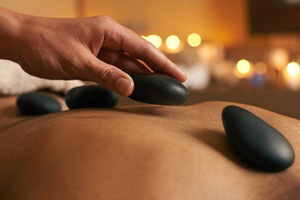 utilisant thérapie alternative - lastone therapy spa treatment health spa massaging photos et images de collection
