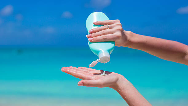 istock Woman hand putting sunscreen from a suncream bottle 498336513
