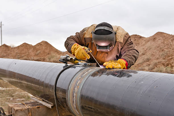 Welding works on gas pipeline Welder mounts in the trunk pipeline electrochemical protection pipeline photos stock pictures, royalty-free photos & images