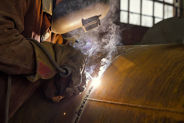 сварщик выполняет сварки большого диаметра трубопровода - welding welder pipeline manufacturing occupation стоковые фото и изображения