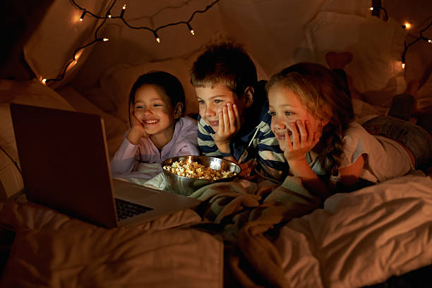 Movie time in the blanket fort Shot of three young children using a laptop in a blanket forthttp://195.154.178.81/DATA/i_collage/pi/shoots/783447.jpg slumber party stock pictures, royalty-free photos & images