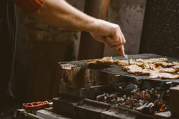 istock Man grilling pork meat chops on barbecue 498339962