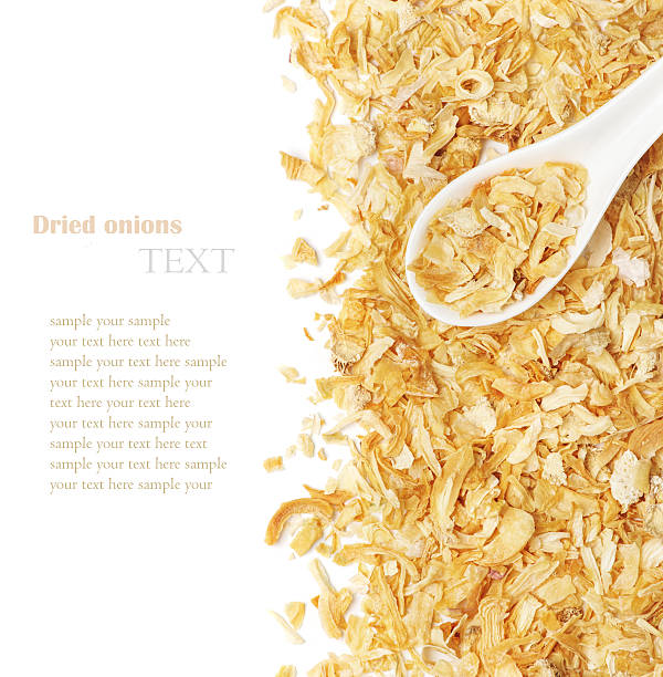 Dried chopped onion in a white ceramic spoon stock photo