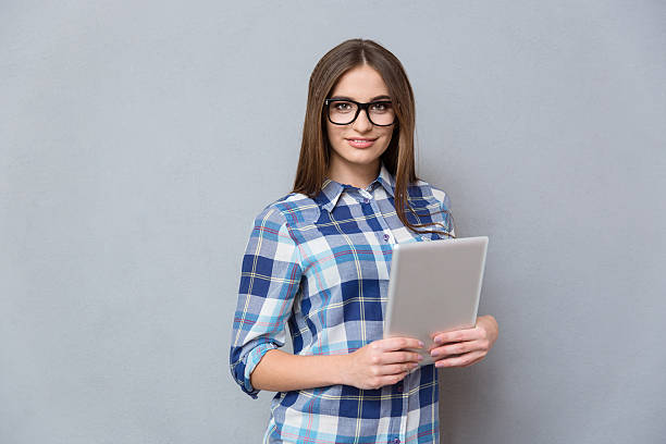 istock Pretty young woman in glasses holding tablet 498341734