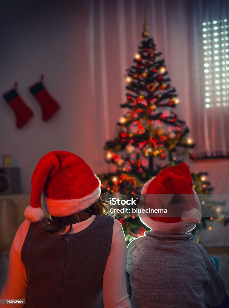 Waiting for Santa Kids waiting for Santa Claus to come in Front of Christmas Tree 2015 Stock Photo
