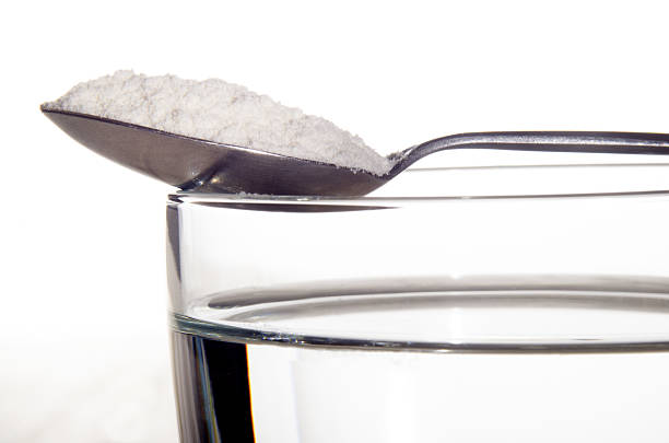 istock water glass with white medicine on a spoon 498344700
