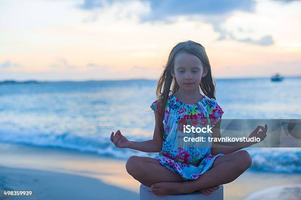 Beautiful Little Girl Sitting In Lotus Position On Exotic Beach Stock Photo - Download Image Now