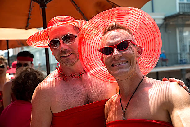 Red dress Run New Orleans New Orleans, USA - August 8, 2015: Couple of guys wearing a red night dress at the Red Dress Run in New Orleans, Louisiana. gay man men sunglasses party stock pictures, royalty-free photos & images