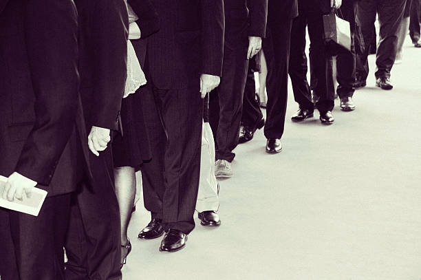 The suits waits in line. Retro black white. Film grain digitally added