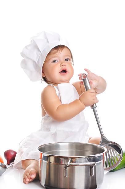 istock Adorable baby boy chef sitting and playing with kitchen equipment 498376888