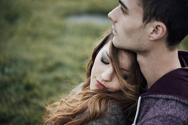 istock Young loving couple sitting on the grass 498377246