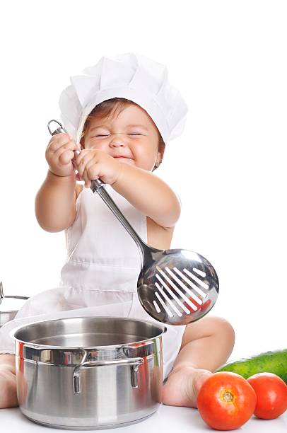 istock Adorable baby boy chef sitting and playing with kitchen equipment 498377914