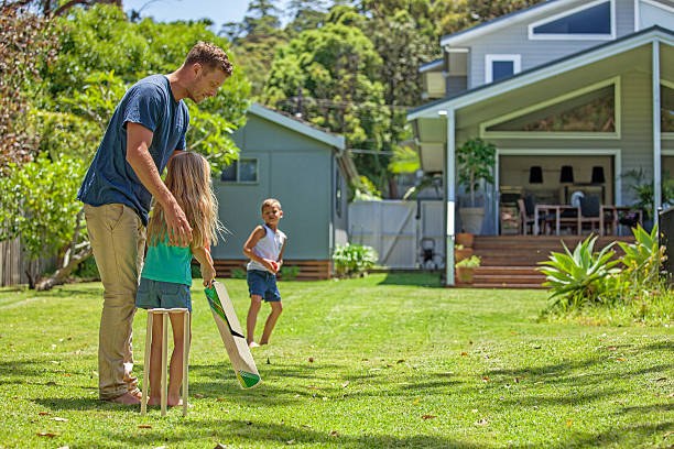 father teaches daughter cricket Kids playing cricket in their backyard. bondi beach photos stock pictures, royalty-free photos & images