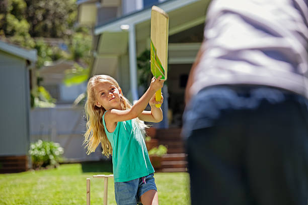 petite fille se balancer à la batte de match de cricket - sport of cricket cricket player cricket bat batting photos et images de collection