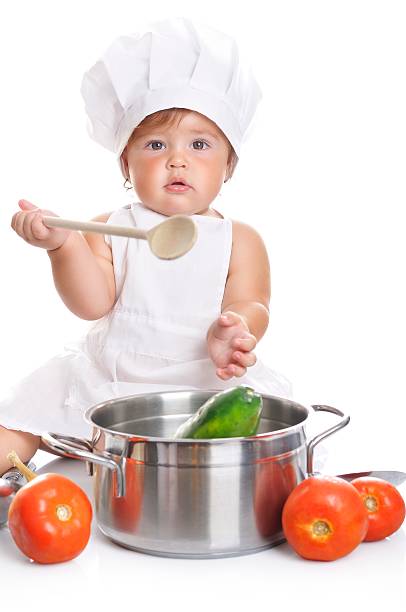 istock Adorable baby boy chef sitting and playing with kitchen equipment 498378312