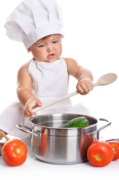 istock Adorable baby boy chef sitting and playing with kitchen equipment 498378524
