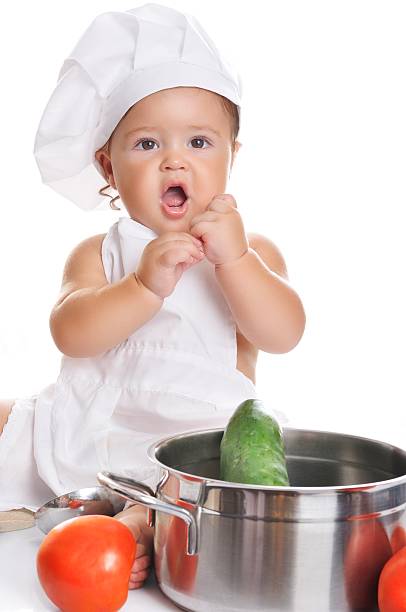 istock Adorable baby boy chef sitting and playing with kitchen equipment 498379566