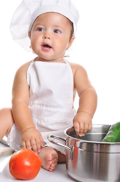 istock Adorable baby boy chef sitting and playing with kitchen equipment 498379748