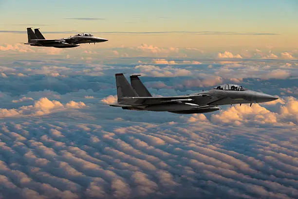 F-15 Eagle fighter jets flying above clouds 