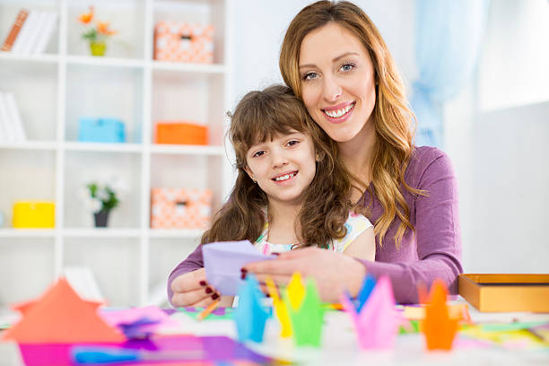 istock Mother and daughter making origami 498385295