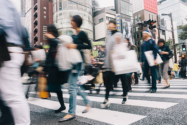 Shopping People Shibuya Crossing Tokyo Crowd of People during rush hour walking over zebra crossing with their shopping bags at Shibuya Crossing in Downtown Tokyo. Motion Blurred People. Tokyo, Japan. tokyo crowds on the famous shibuya crossing japan stock pictures, royalty-free photos & images