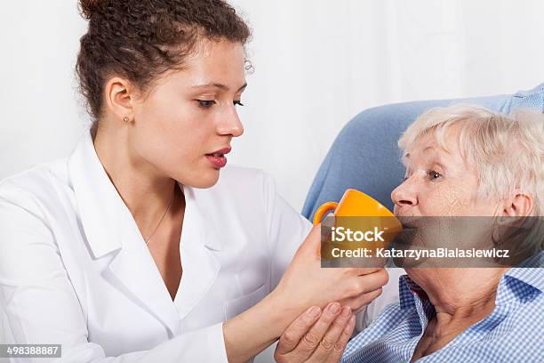 Nurse Gives Drinking Old Woman Stock Photo - Download Image Now - Adult, Aging Process, Assistance