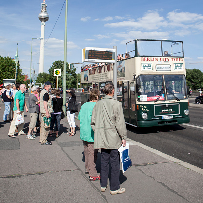 Berlin, Germany - May 23, 2011: A group of elderly passengers waiting to board a Berlin City Tour bus on the busy tourist street of Unter Den Linden in the centre of the German capital on a bright and sunny spring day.