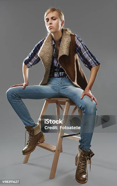 Foto de Andrógino Garota Sentase Em Uma Cadeira Jeans E Jaqueta e mais fotos de stock de Adulto