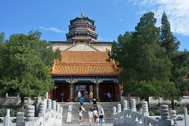 Beijing, China - July 27, 2013. People walking toward pagoda in Summer Palace (pronounced as Yihe Yuan in Chinese). Summer Palace was originally built in 1750 and is the largest well-preserved royal palace in China. It was listed as a World Heritage Sites by UNESCO in 1998. It is a masterpiece of Chinese garden design.