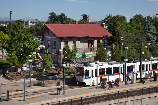 Littleton, Colorado, USA - June 13, 2014: A southbound RTD light rail train pulls up to the Littleton Station as passengers wait for a northbound train.