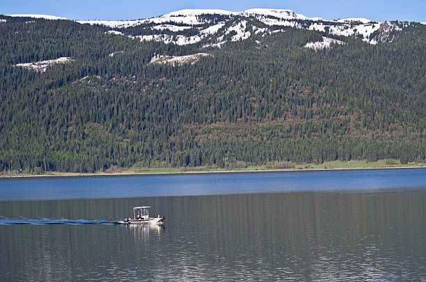 istock Recreational Boat Sailing Across Snow Covered Mountain Lake 498397653