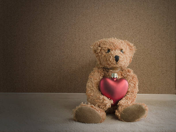 istock Teddy bear sitting with red heart background 498399556