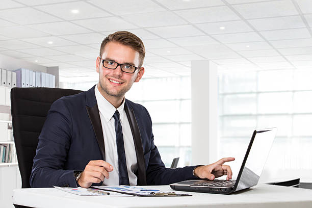 istock Young businessman posing in front of laptop 498404646
