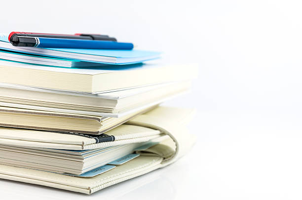 istock stack of organizer, notebooks, pen and pencil on white backgroun 498405542