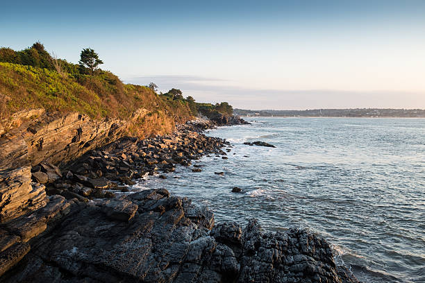 Daylight photo morning ocean vista with cliff and rocky beach