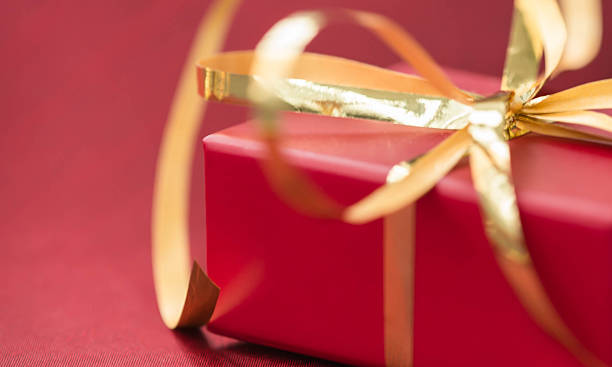 istock Red gift box with golden ribbon on a red background 498409148