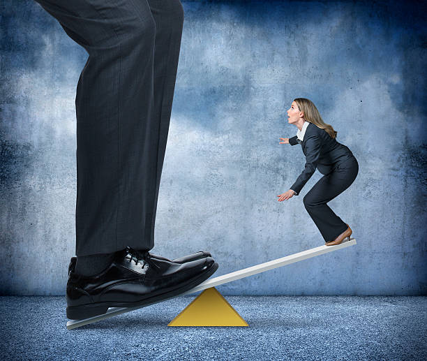 istock Large Businessman Holding Down One End Of Seesaw 498421296