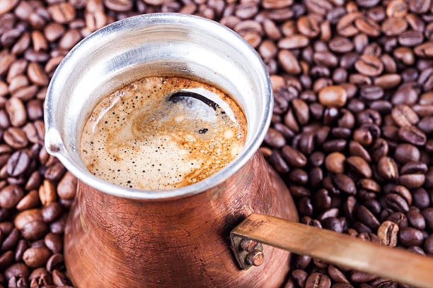 istock Coffee beans, vintage copper coffee pot closeup, cezve or ibrik 498422372
