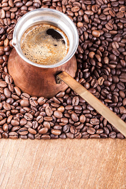 istock Coffee beans, vintage copper coffee pot closeup, cezve or ibrik 498422434