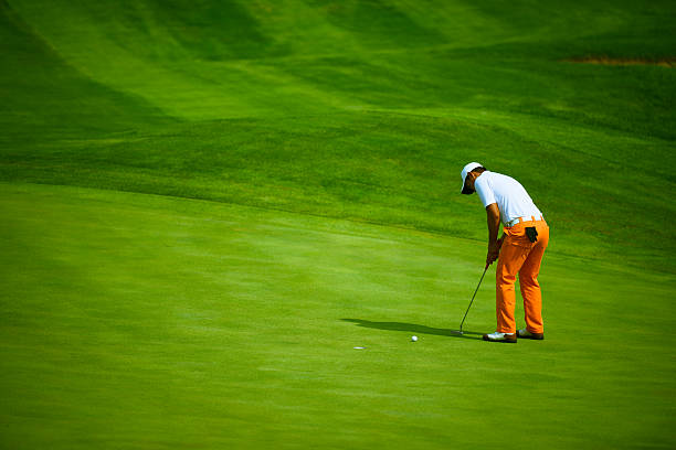 Professional Golf Putting A professional golfer is putting on green golfer stock pictures, royalty-free photos & images