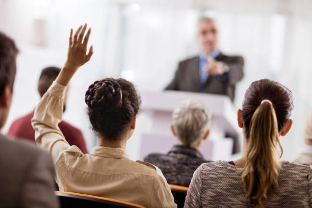 istock Rear view of a woman asking a question on seminar. 498424932