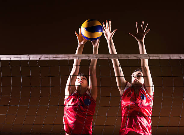 Volleyball action. Two female volleyball players on the net.    volleyball stock pictures, royalty-free photos & images